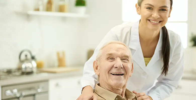 A happy senior sitting at home with a caregiver.