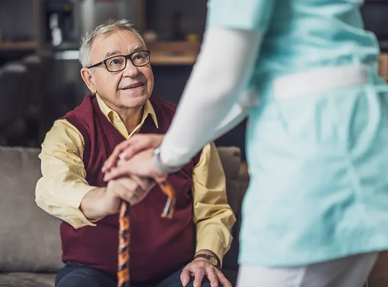 A therapist guiding a patient through exercises at home.